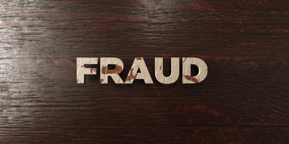 FRAUD made of wood on a wooden surface 