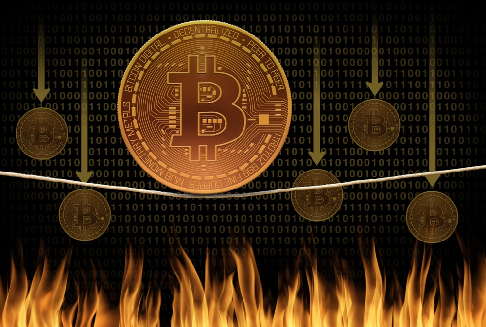 Bitcoin on a rope above fire with bitcoin falling down 