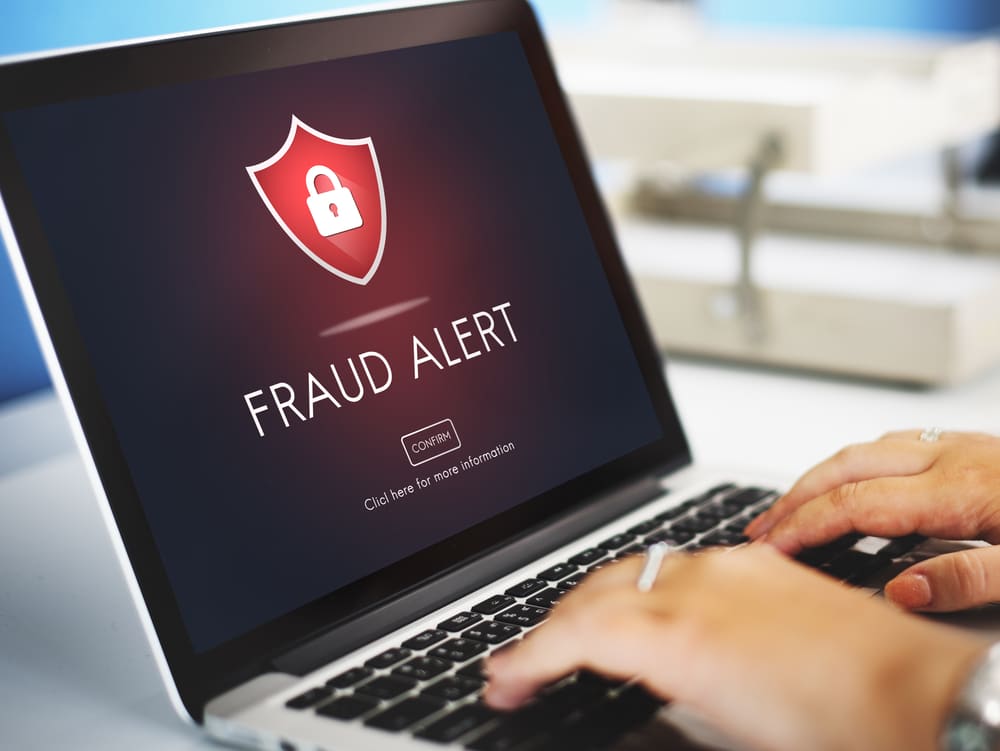 FRAUD ALERT graphic art on a laptop screen