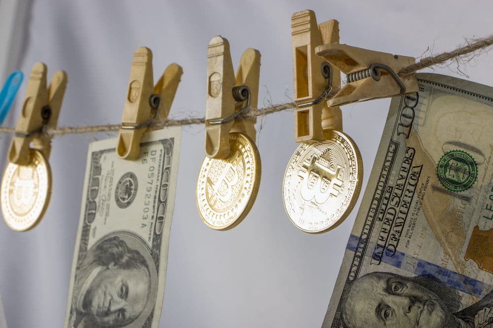 Bitcoins and USD bills hanging up on a laundry line