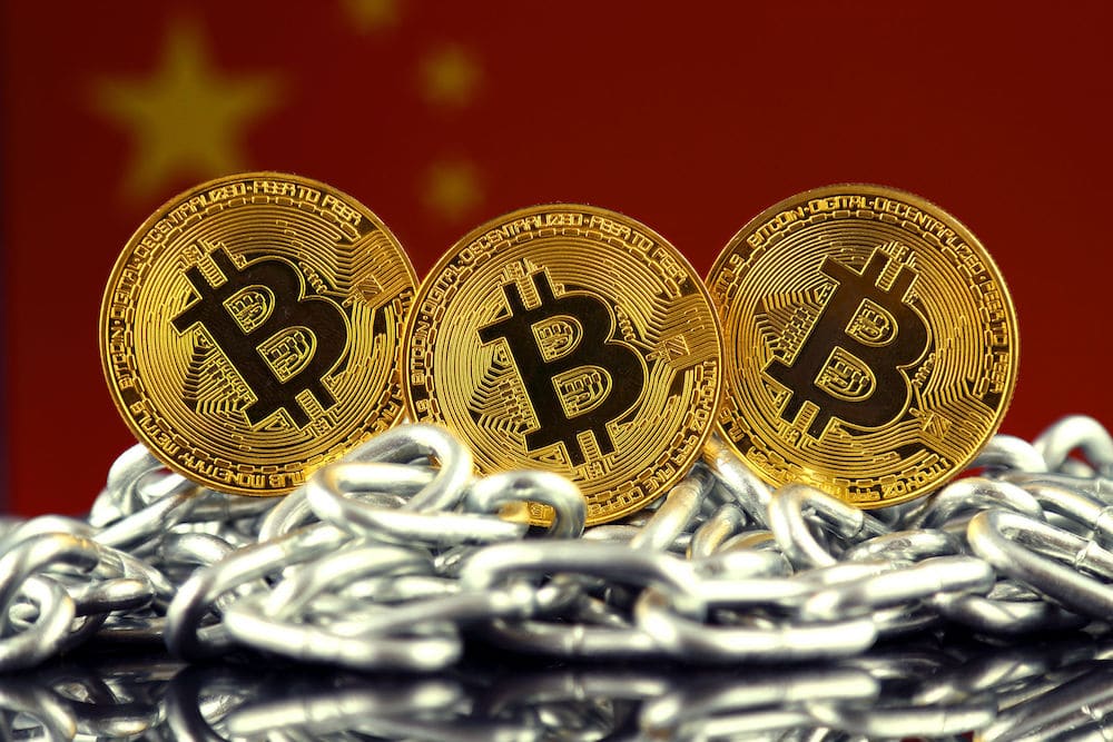 Bitcoin coins on top of chains, in front of the Chinese flag