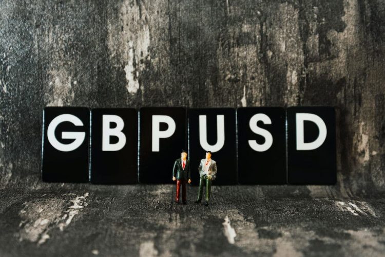 Two toy men standing in front of blocks reding GBPUSD