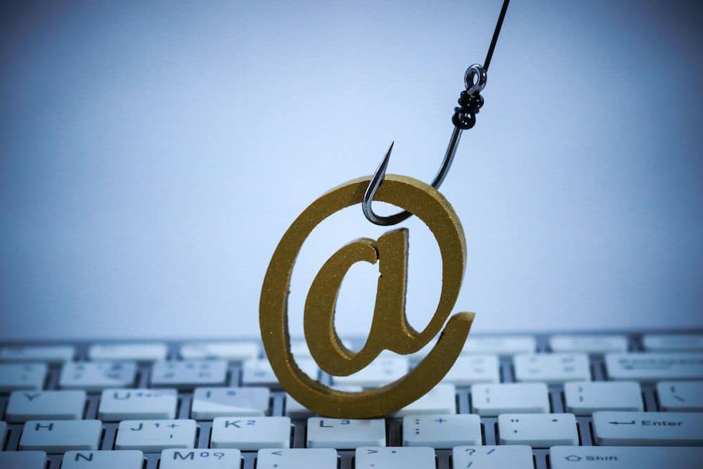 At Sign statue on top of a keyboard, being hooked 