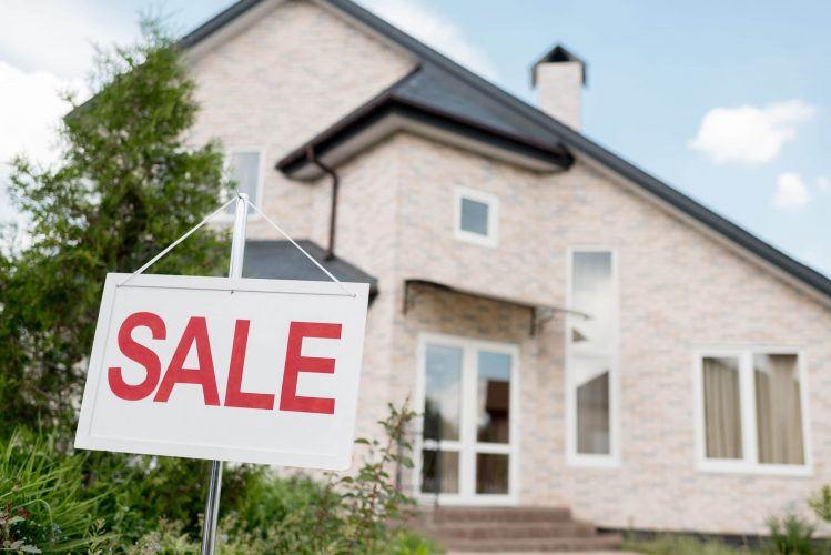 SALE sign in front of a home