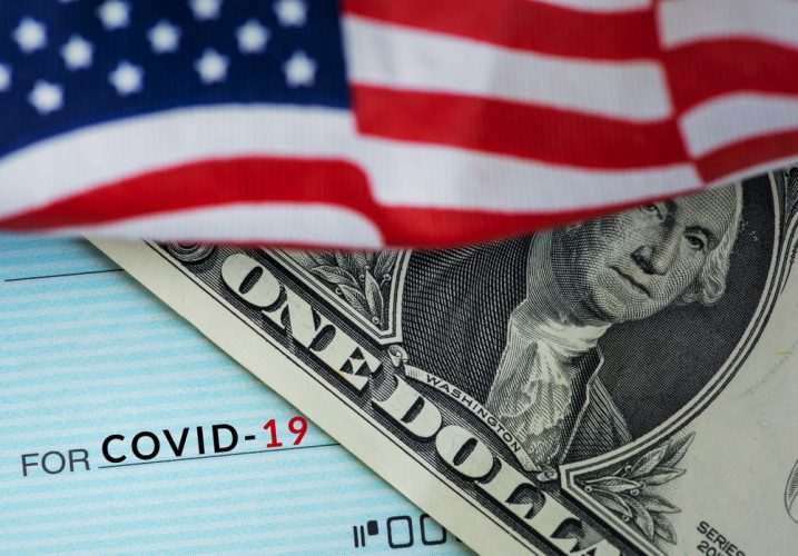 American Flag and Dollar Bill on top of a cheque with COVID19 written down