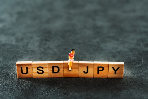 Toy Blocks with Letters Reading USDJPY with toy man sitting on top