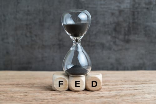 A sand hourglass on top of wood blocks that read FED