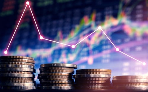 Coins in front of Forex Stock Market graphs